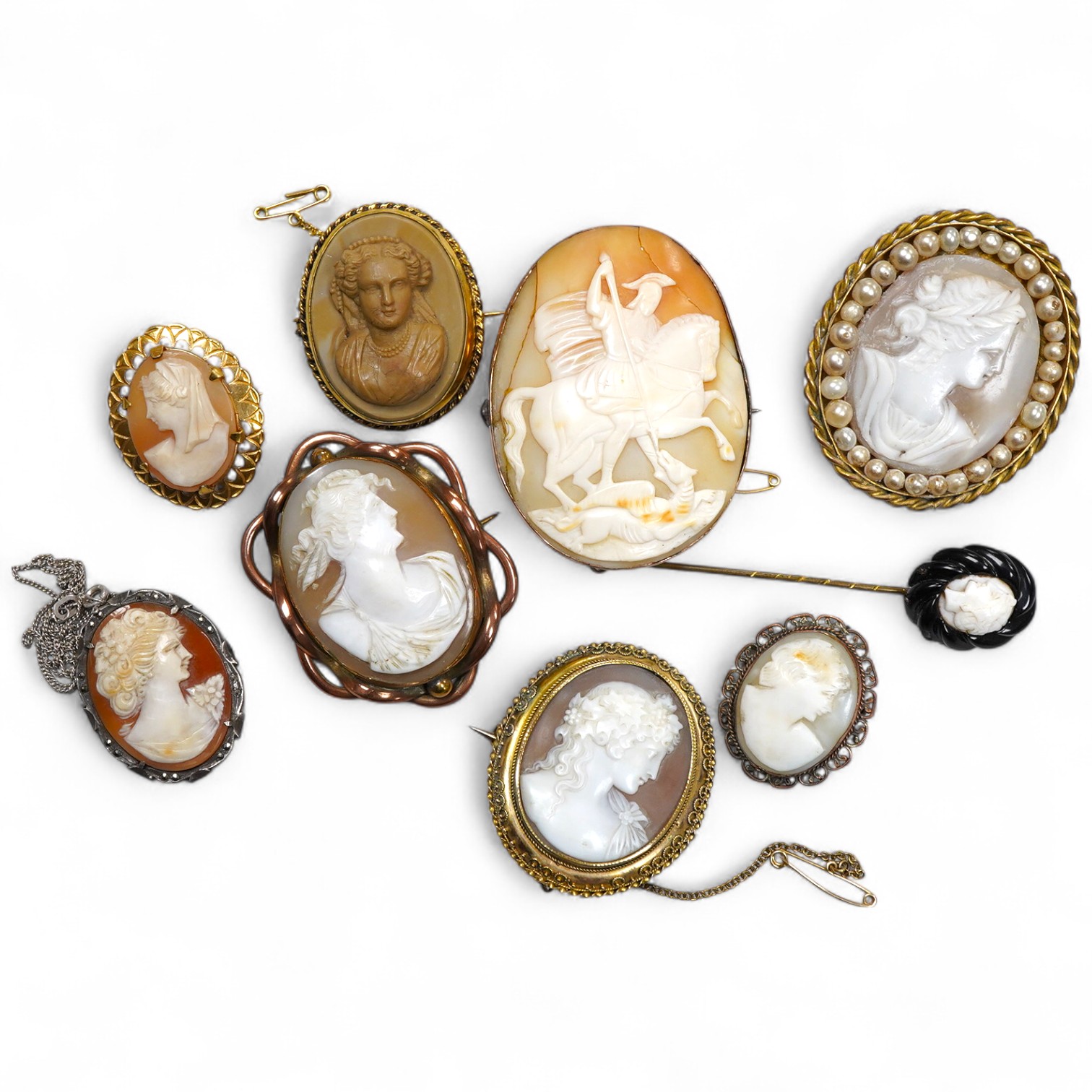 A collection of shell cameo brooches, comprising: a cameo depicting Bacchus, in a gold mount in the Archaeological Revival style, decorated with rope twist and a twisted knife wire border, length 4.4cm; together with sev